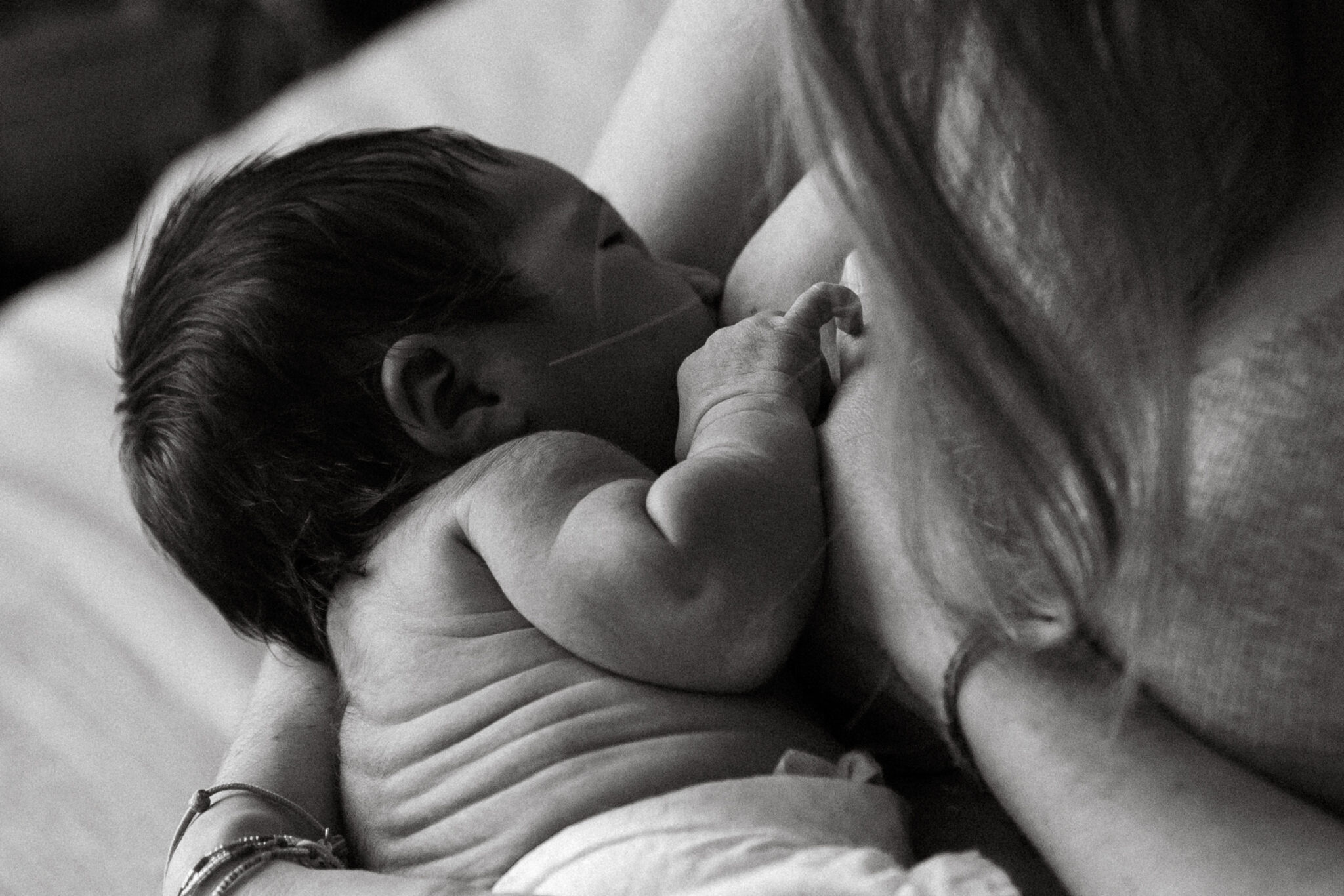 séance naissance, moment d'allaitement en peau à peau par Evelyne Oustrain Photographe